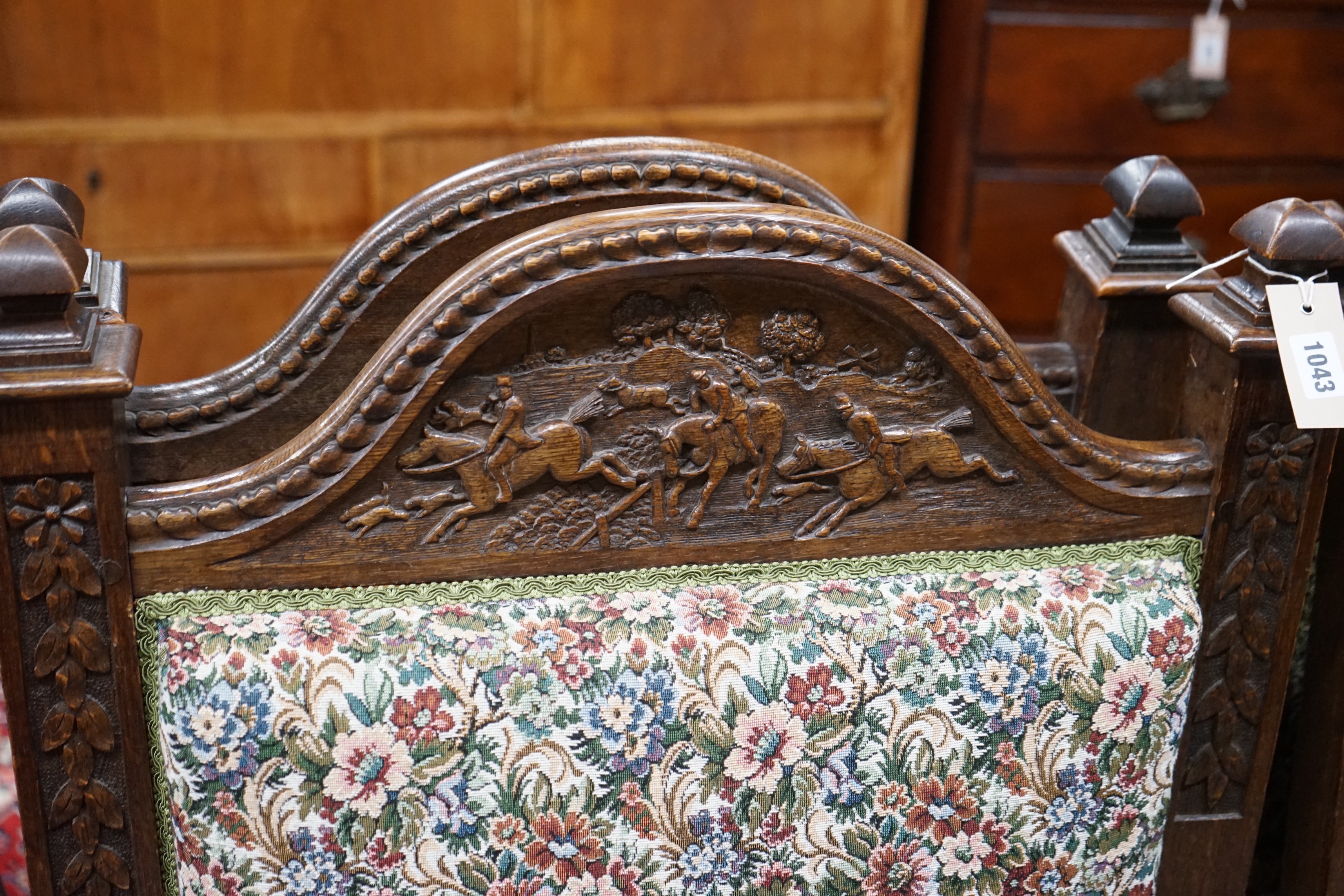 Seven (6+1) early 20th century carved oak upholstered X frame elbow chairs, largest width 75cm, depth 62cm, height 114cm